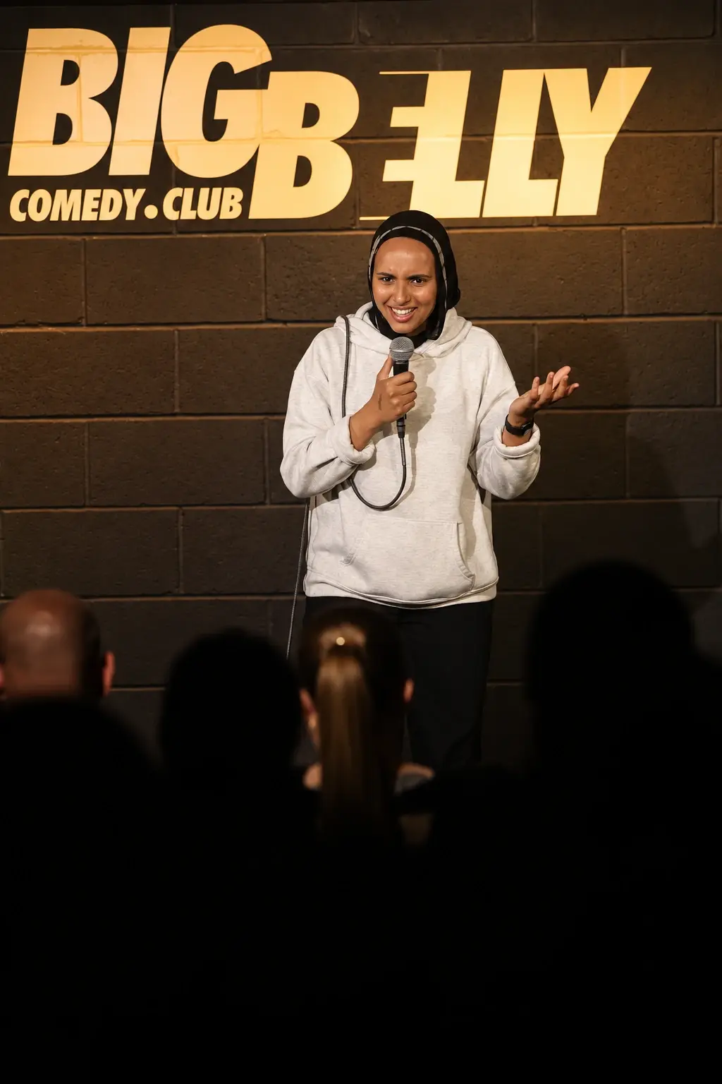 Fathiya Saleh holding a microphone on the Big Belly stage